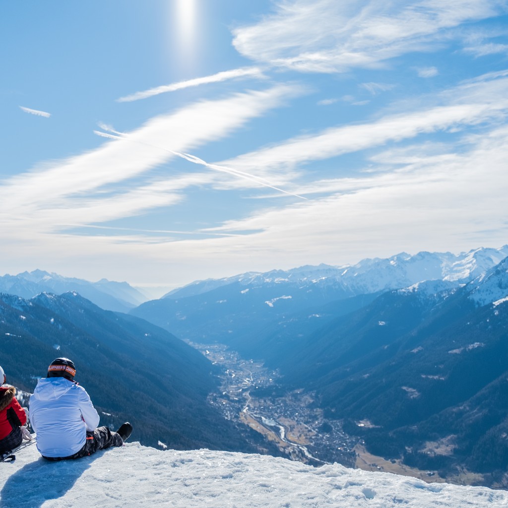 A beautiful shot of two persons enjoying the view of mountains and valley during daytime